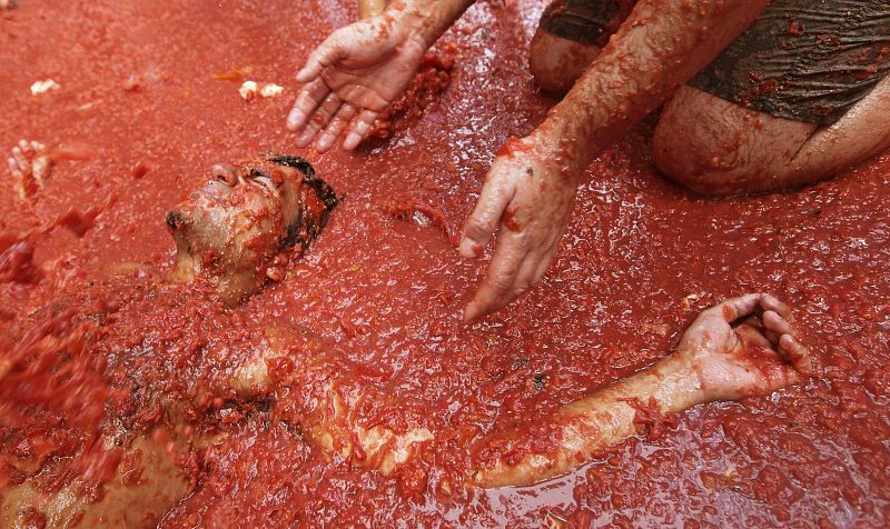 Un joven se tumba en el suelo cubierto de tomate hoy en Buñol (Valencia)