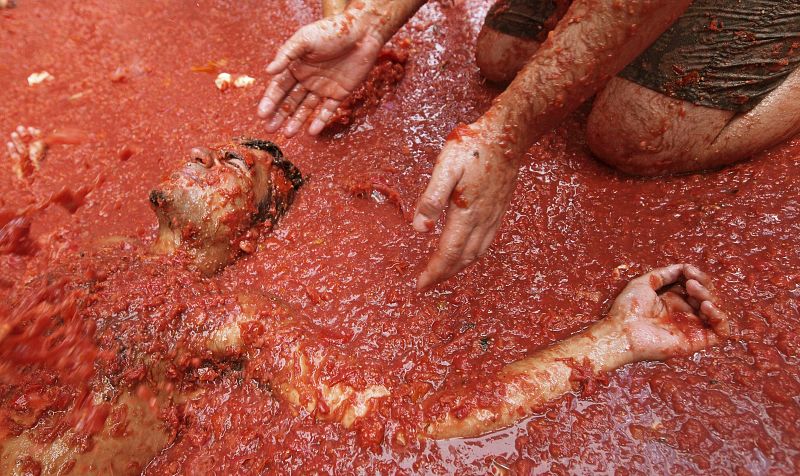 Un joven se tumba en el suelo cubierto de tomate hoy en Buñol (Valencia)