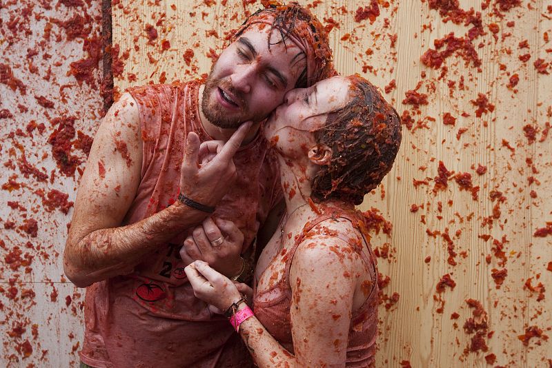 Una pareja cubierta de tomate se besa durante la Tomatina de Buñol (Valencia)