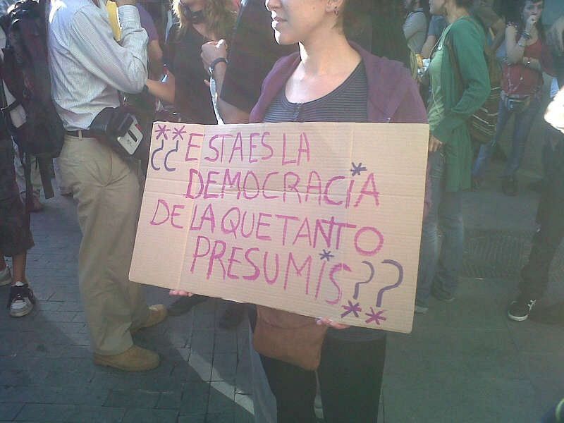 Una participante de la manifestación contra la reforma constitucional muestra uno de los lemas