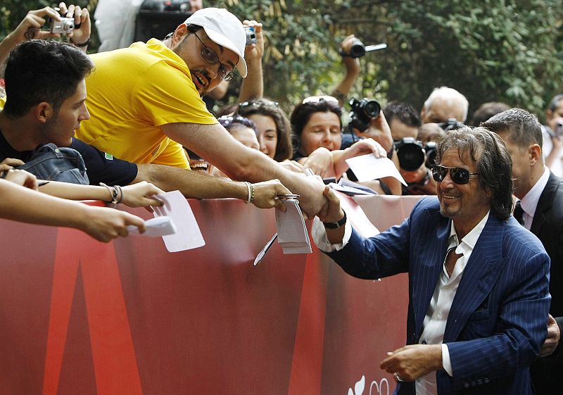 Director and actor Al Pacino shakes hands with fans as he arrives for a news conference of his film Wilde Salome at the 68th Venice Film Festival