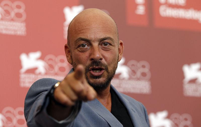 Director Emanuele Crialese points as he poses during a photocall for his film "Terraferma" at the 68th Venice Film Festival