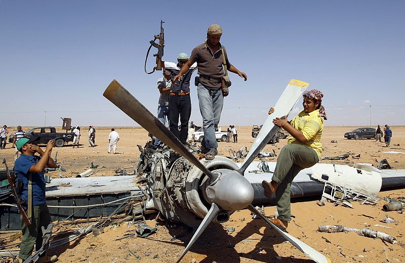 Los soldados rodean parte del fuselaje de los aviones destruidos por la OTAN