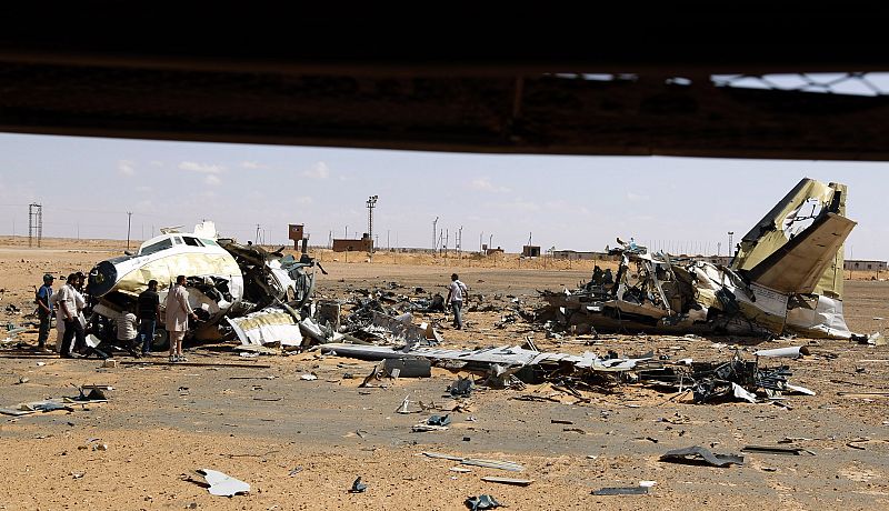 Soldados rebeldes junto a uno de los aviones destruídos en la base de Khamis