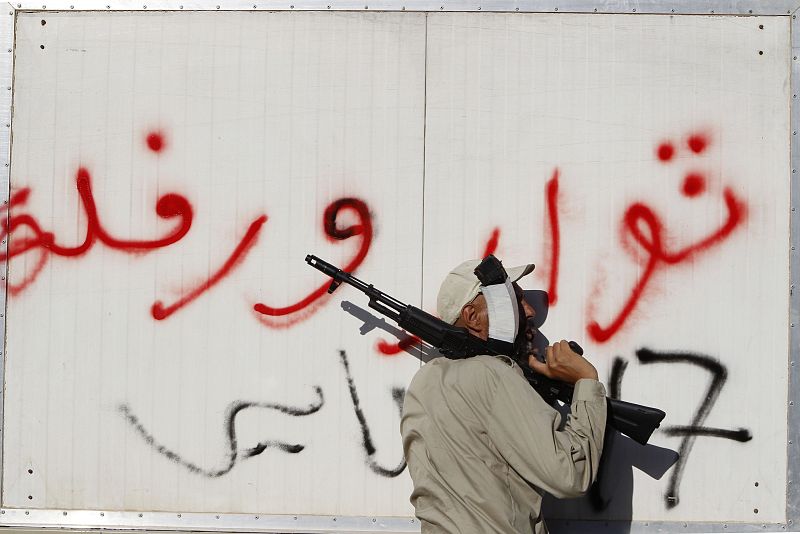 Un policía rebelde controla un camión cerca de la aldea de Al malti
