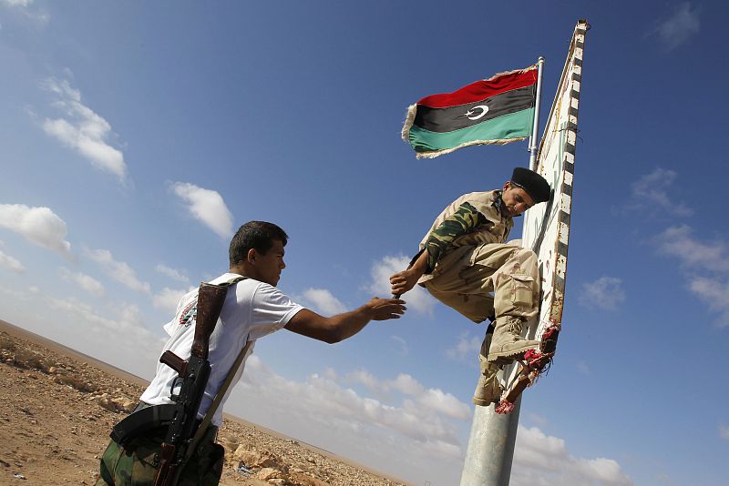 Los rebeldes colocan una bandera de la nueva Libia a las afueras de la ciudad cercada de Bani Walid