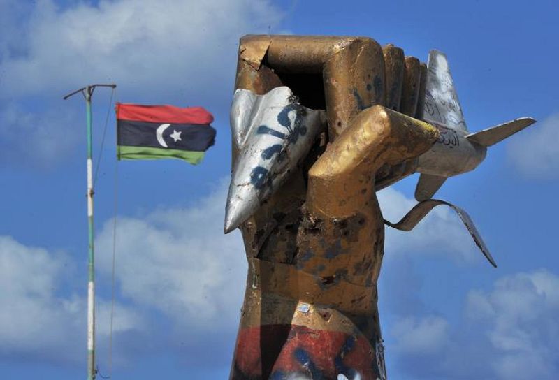 Una bandera de la nueva Libia ondea junto al emblemático monumento del régimen de Gadafi en Misrata