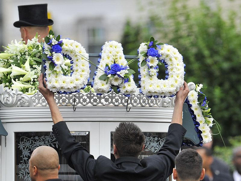 Colocan una corona de flores con la palabra dad (papá) en el carruaje