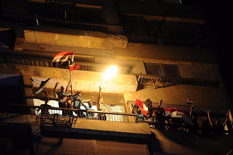 Manifestantes egipcios se suben a un edificio de la embajada de Israel