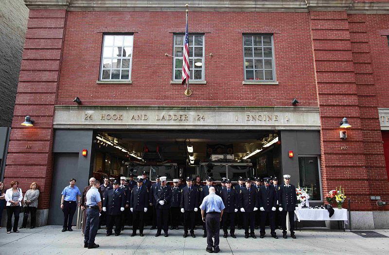 Firefighters observe a moment of silence at FDNY firehouse Hook & Ladder 24 Engine 1 during ceremonies marking the 10th anniversary of the 9/11 attacks on the World Trade Center, in New York