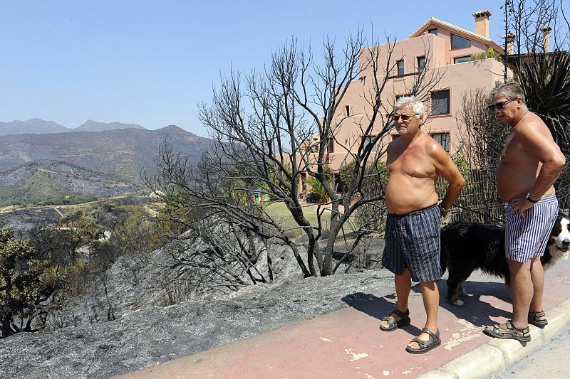 Unos vecinos miran cómo ha quedado su casa