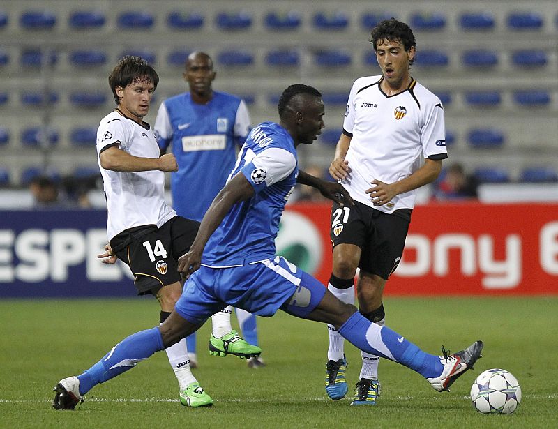 Piatti toca el balón ante la mirada de Parejo y la oposición de Nwanganga en el Genk - Valencia