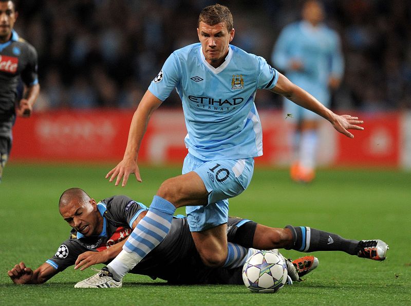 Dzeko, delantero del Manchester City, trata de llevarse el balón ante la oposición de Gokhan, del Nápoles