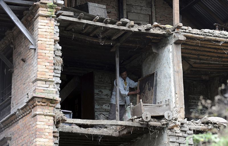 Un nepalí limpia los escombros de su casa en Bhaktapur, 12km al sureste de la capital, Katmandú