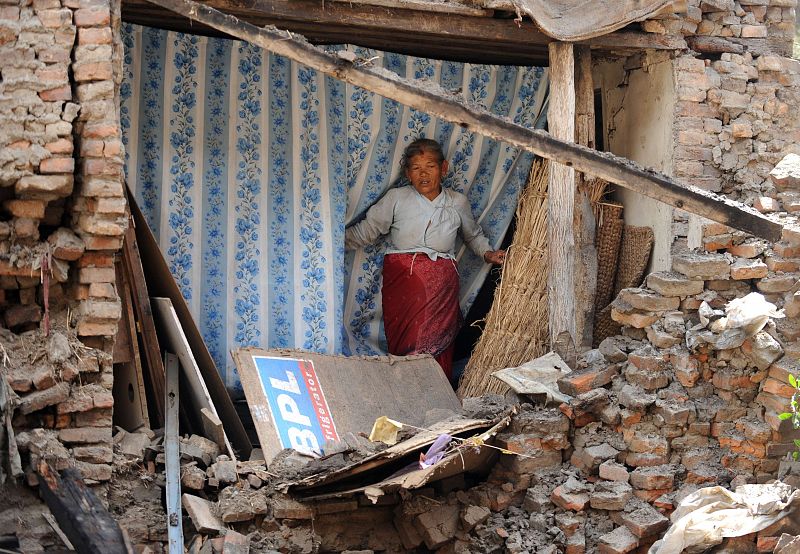 Shuvadra Pathi, vecina de Katmandú, observa una casa que se ha venido abajo con el temblor en la capital de Nepal