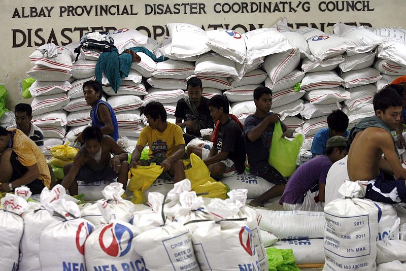 Varios trabajadores hacen paquetes de arroz en Legazpi, región de Bicol, Filipinas