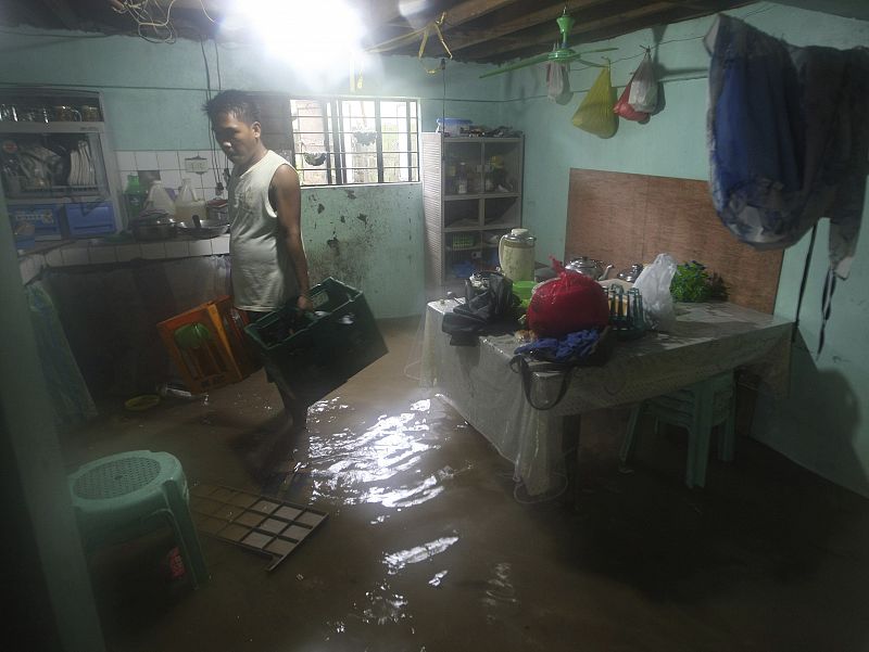 Un filipino recoge sus pertenencias de su casa inundada en San Mateo, Filipinas,