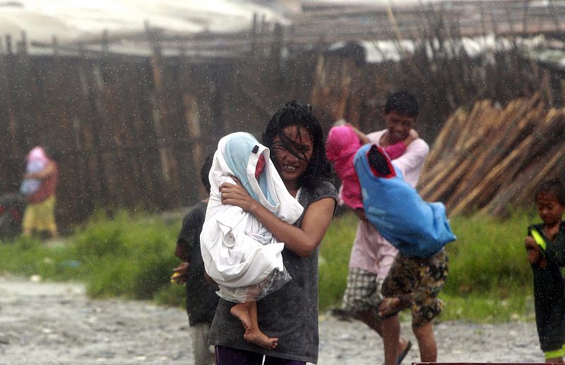 Un filipino lleva su hija durante la evacuación de chabolas en Baseco