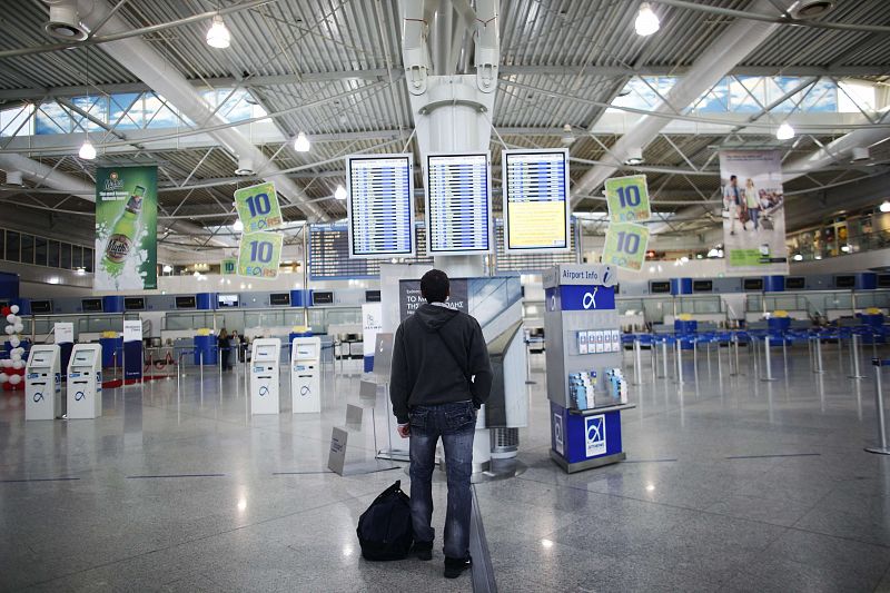 Un pasajero contempla los paneles de información del aeropuerto de Atenas