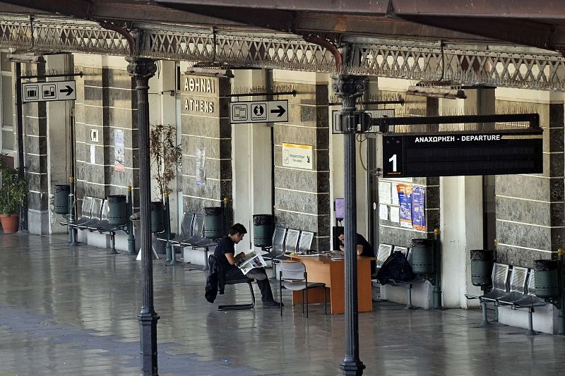 Dos guardas de seguridad leen la prensa en la estación de tren de Atenas, sin afluencia de gente