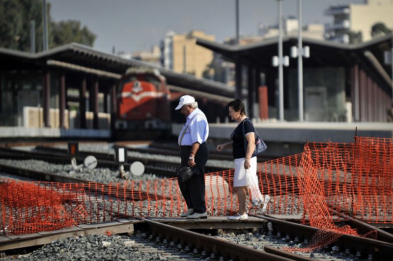 Una pareja cruza las vías del tren durante la huelga general