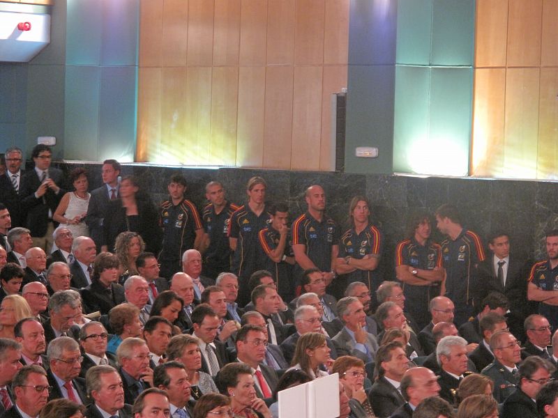 Los asistentes a la entrega de las Reales Ordenes al Mérito Deportivo con los jugadores de la selección española de fútbol al fondo.