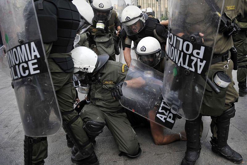 Varios policías detienen a uno de los manifestantes en Atenas