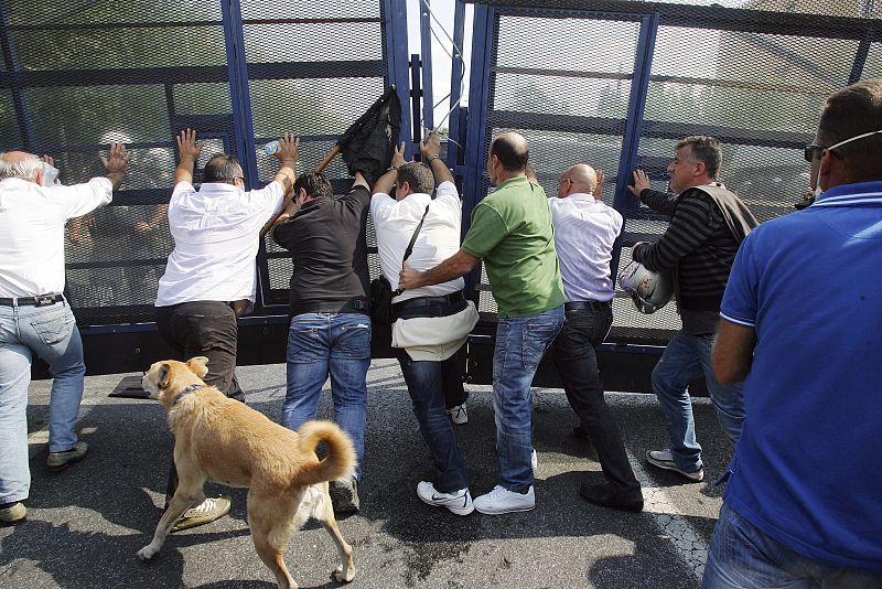 Los manifestantes empujan una puerta para bloquear el paso a la policía en la plaza Sintagma