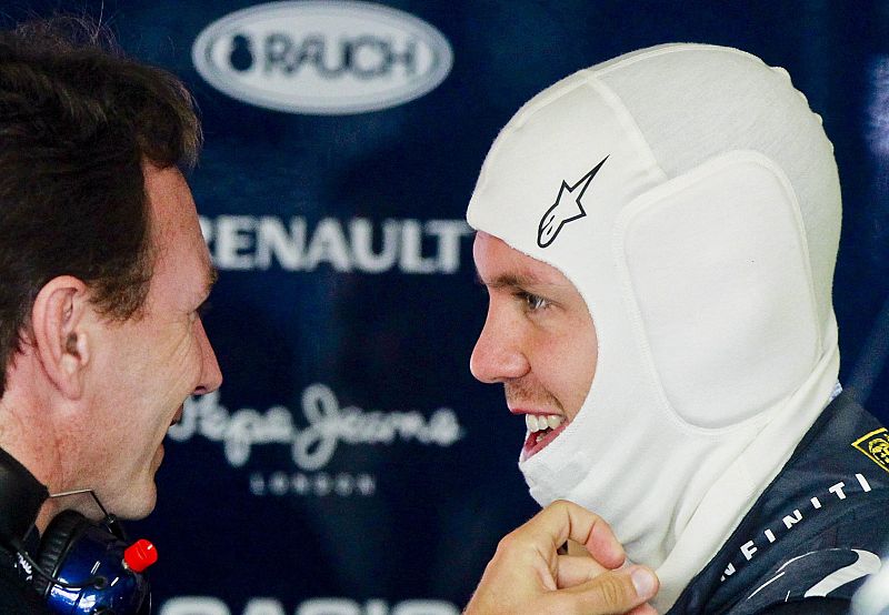 El piloto alemán Sebastian Vettel (d) conversa con el director de su equipo Christian Horner (i) en el Gran Premio de Japón.