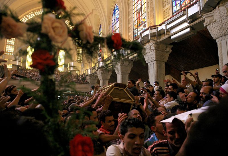 Un féretro es introducido en la catedral de Abbasiya en El Cairo, Egipto, durante el funeral por los coptos fallecidos en los choques contra militares en el centro de la capital egipcia.