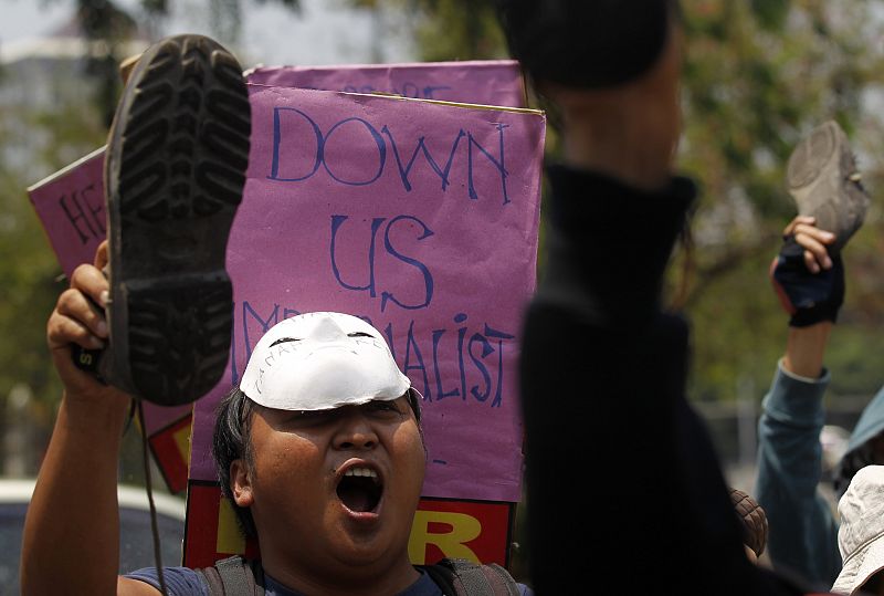 People wave shoes outside the U.S. embassy in a protest galvanised by the Occupy Wall Street movement in New York, in Jakarta