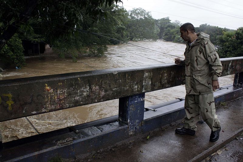 Este hombre mira sobre un puente las inundaciones que han tenido lugar en Ciudad Arce.