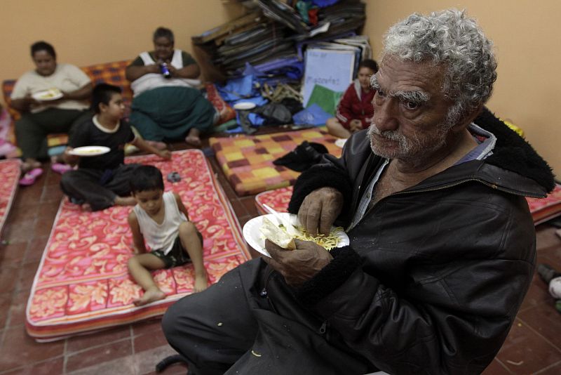 Un grupo de personas comen en un albergue tras haber sido evacuadas de sus hogares.