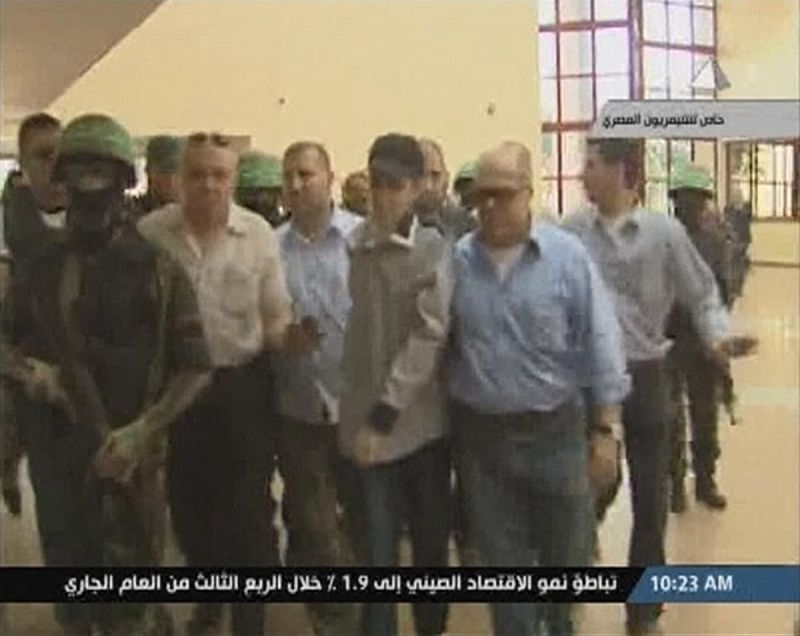 Imagen tomada de televisión de Shalit escoltado en Egipto tras su liberación