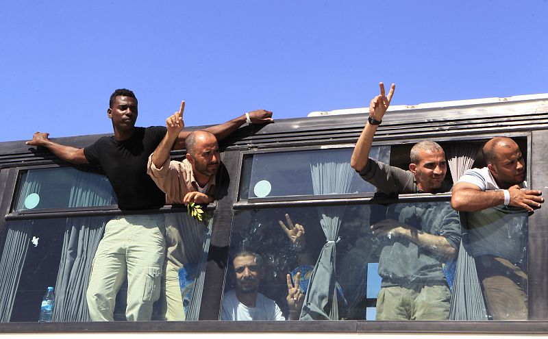Algunos de los palestinos liberados hacen el signo de la victoria al cruzar el paso de Rafah hacia Gaza