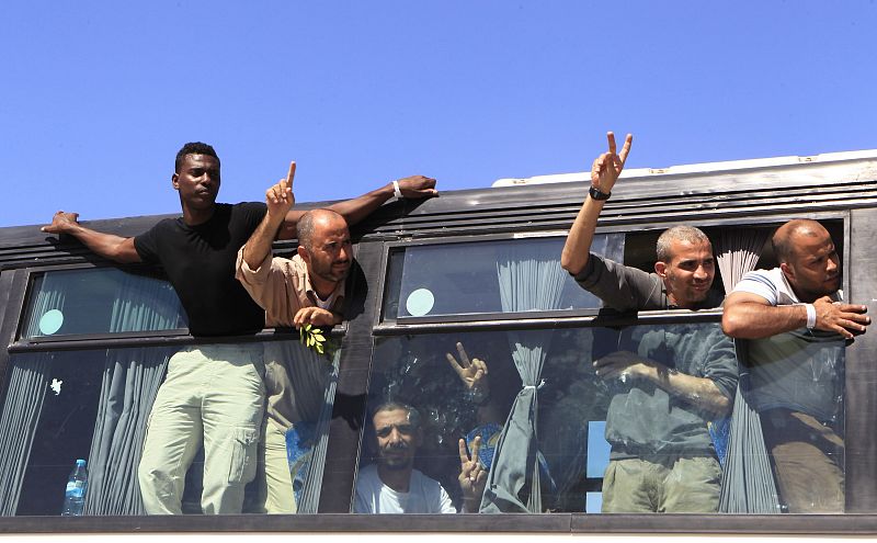 Algunos de los palestinos liberados hacen el signo de la victoria al cruzar el paso de Rafah hacia Gaza