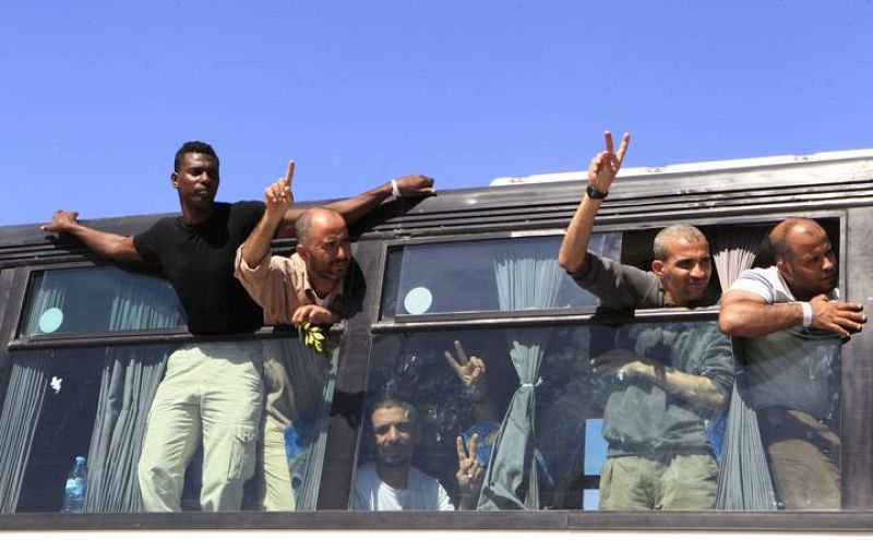 Algunos de los palestinos liberados hacen el signo de la victoria al cruzar el paso de Rafah hacia Gaza