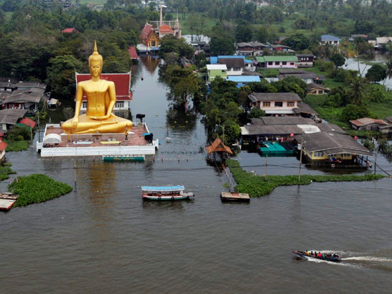 Botes salvavidas pasan junto a un buda gigante en Bangkok