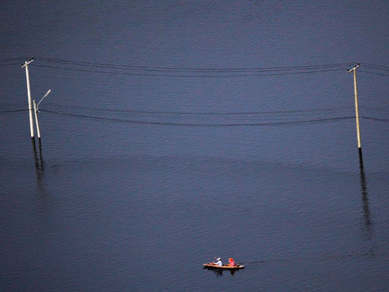 Una barca recorre un barrio inundado en los suburbios de la capital tailandesa