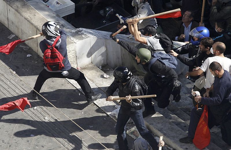 Las manifestantes del partido comunista, de negro, se enfrentan con un grupo de radicales