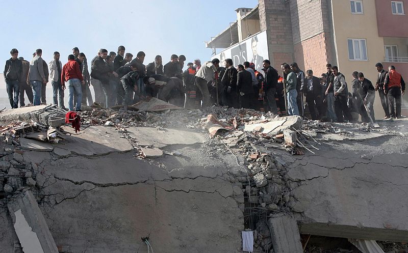 Varias personas observan el estado en el que ha quedado un edificio en Van