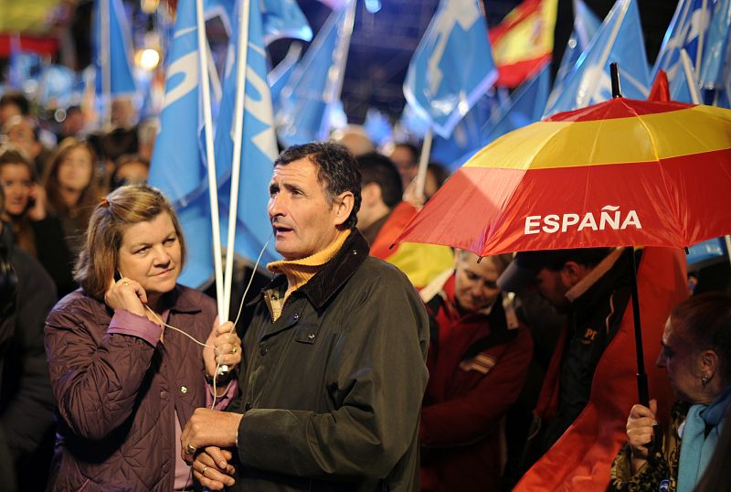 Dos simpatizantes del PP siguen atentos desde Génova el escrutinio de los votos.