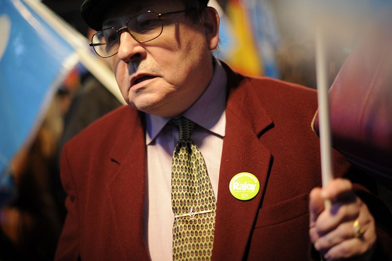 Un simpatizante del PP, con una chapa que lleva escrita 'Rajoy', sigue el recuento de votos desde la sede de los 'populares'.