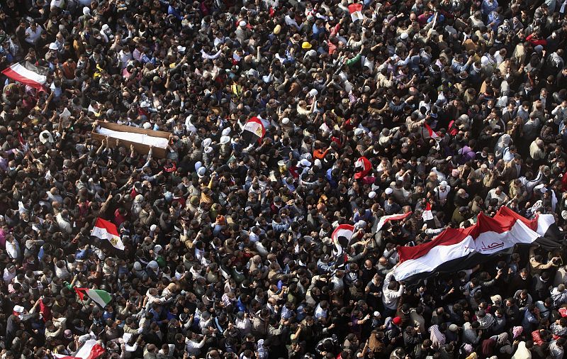 Los manifestantes de Tahrir portan una bandera en la que aparece escrito: "Te queremos Egipto"