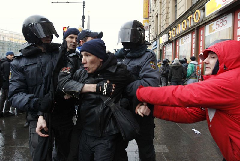 Policemen detain an activist during a rally to protest against violations at the parliamentary elections in St. Petersburg