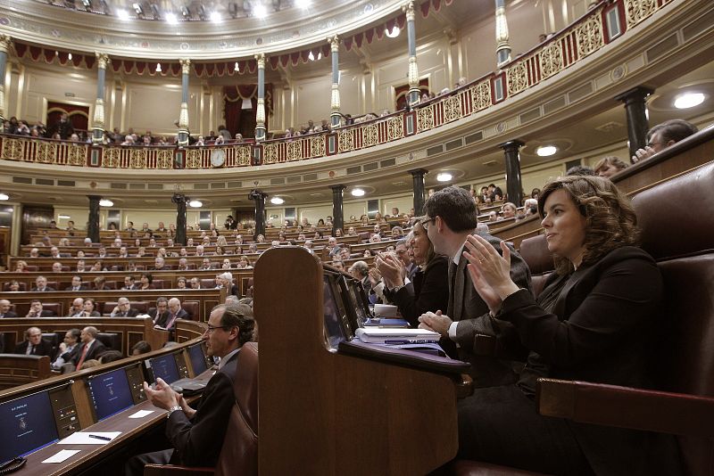 La hasta ahora portavoz del PP en el Congreso de los Diputados, Soraya Sáenz de Santamaría, y la bancada 'popular' aplaude a Mariano Rajoy durante su discurso.