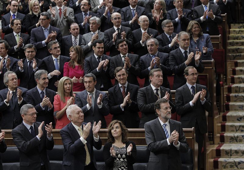 El nuevo presidente del Gobierno, Mariano Rajoy, los ministros y su grupo parlamentario aplauden durante el discurso
