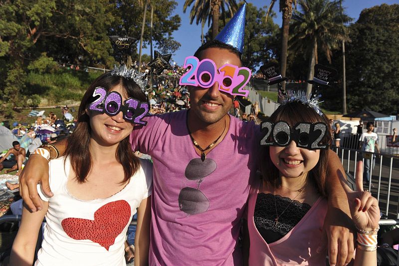 Tres jóvenes posan durante uno de los espectáculos previos para celebrar la llegada del Año Nuevo, en Sídney, Australia.