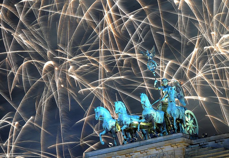 Fuegos artificiales se encienden sobre la puerta de Brandenburgo.