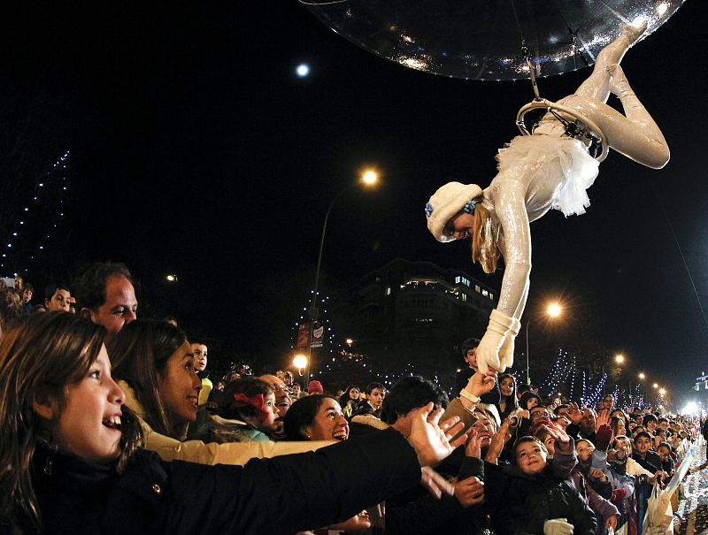 Un paje real saluda a los niños que han asistido a la cabalgata de los Reyes Magos en Madrid.